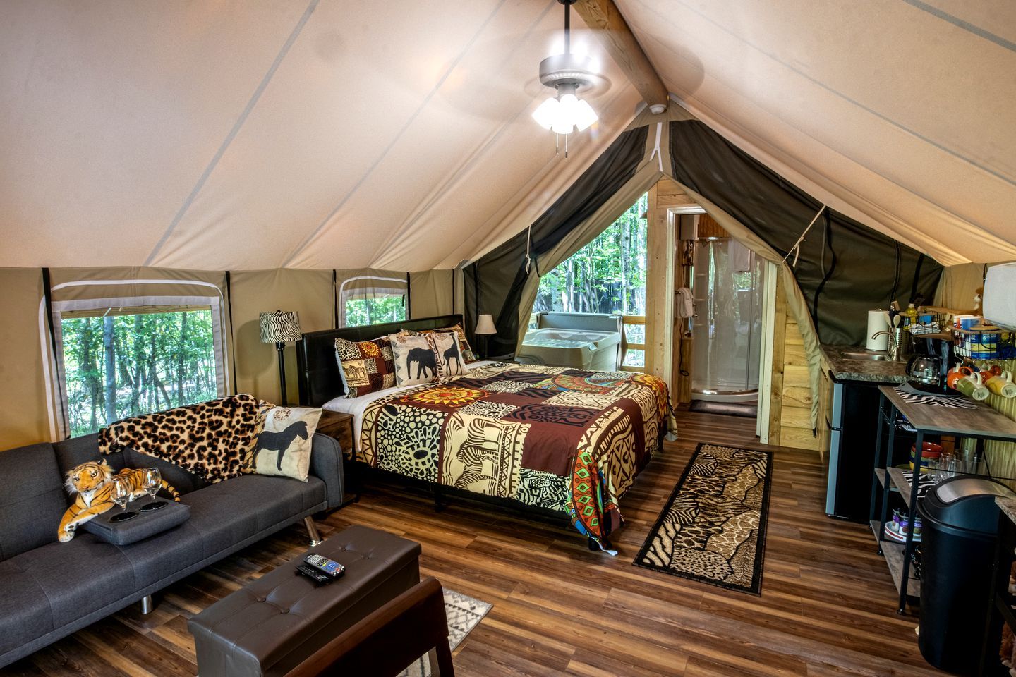 Un hébergement sous tente comprenant un lit, un canapé et une kitchenette.