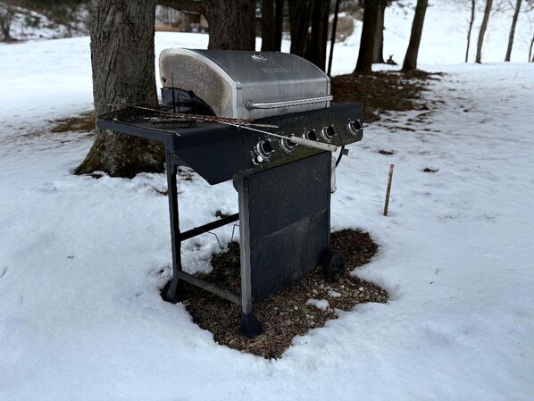 Un barbecue portable installé dans un espace extérieur enneigé.