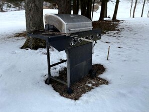 A portable grill set up in a snowy outdoor area.