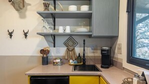 Eine kleine Küche mit Kühlschrank, Spüle und Fenster.