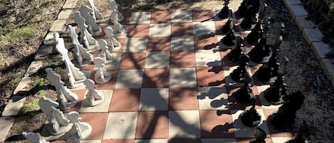 A chessboard set outdoors with pieces arranged for a game.