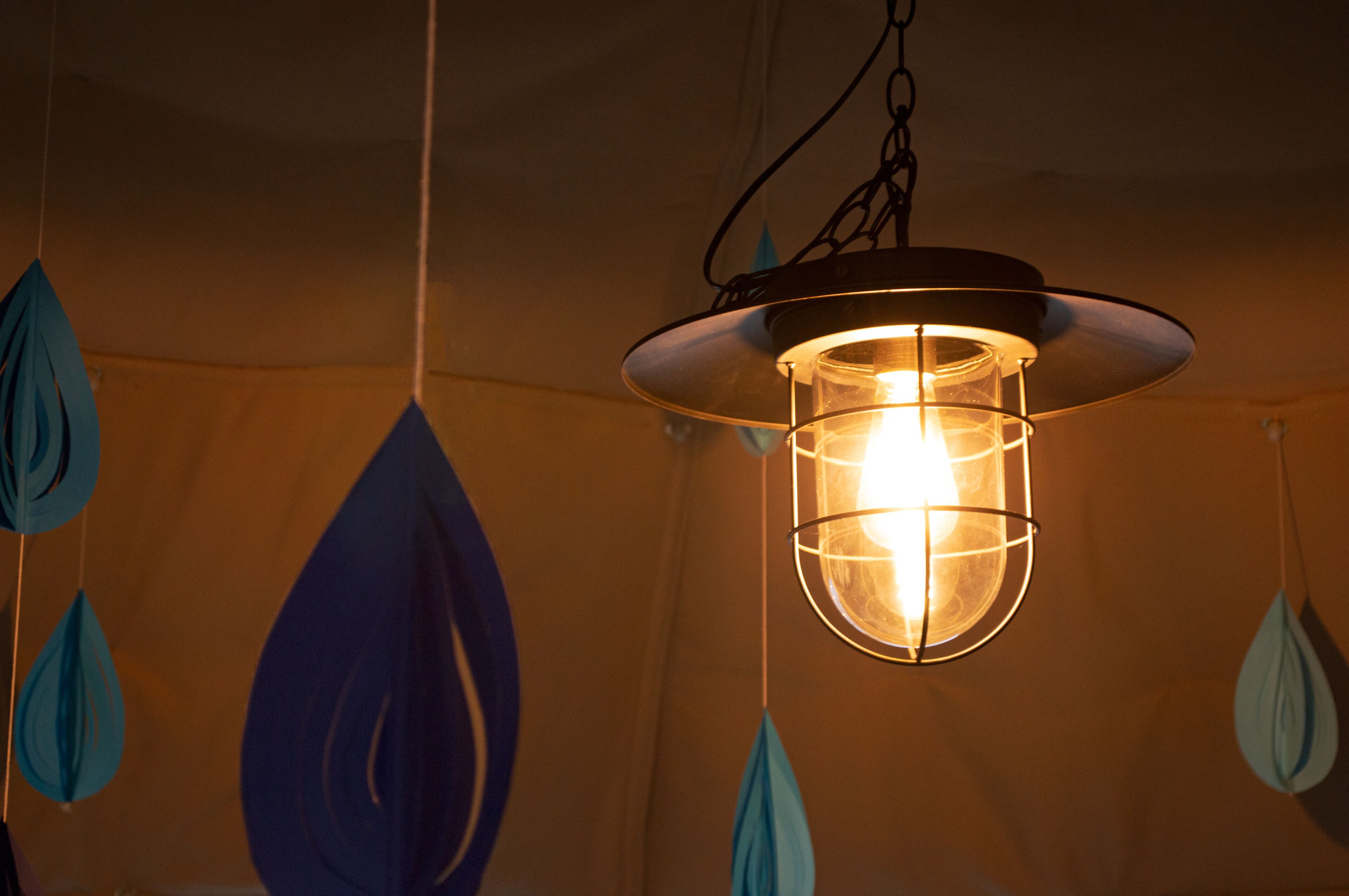 A hanging light fixture with a circular shade and a visible bulb.