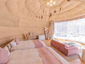 A tent-style room with two beds, a sofa, a small table, and a window with a view of buildings. - yamagata glam (Murayama)