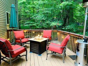 Une terrasse aménagée avec du mobilier d’extérieur, un foyer et un barbecue.