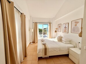 A bedroom with a bed, nightstand, and a view of the outdoors. - Arcadia 3 Private Terraces & Sea Views (Benalmádena)
