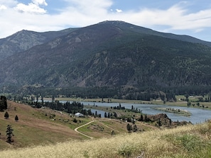 A mountainous landscape with a river, a small settlement, and a clear sky. - Stunning Off-Grid Dome with Spectacular Views for a Unique Glamping Getaway in Montana (Plains)
