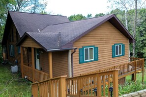 Eine Holzhütte mit Veranda, einer überdachten Terrasse und einem geneigten Dach.