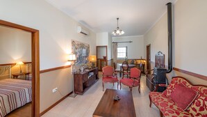 A living room with a sofa, chairs, a coffee table, a fireplace, and a dining area with a table and chairs.