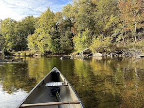 A canoe on a river with trees in the background.