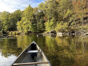 Una canoa en un río, con árboles al fondo.