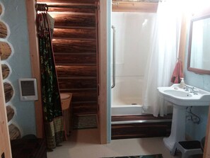 A bathroom with a shower, a sink, and a toilet.