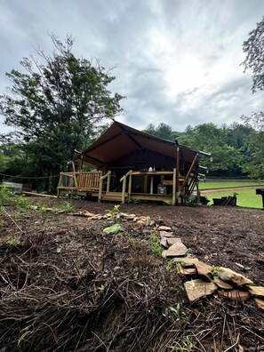 Un rustico chalet in legno con veranda, immerso in un paesaggio naturale.