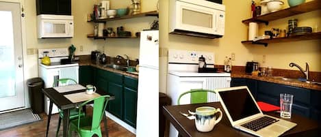 A compact kitchen with a microwave, stove, and sink. There is a laptop on a table and a chair.