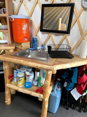 A wooden utility cart with a sink, storage shelves, and a mirror. - Peaceful Denali Accommodation for Yurt Glamping in Alaska (Cantwell)