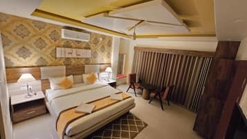 A hotel room with a large bed, bedside tables, a desk, and a chair.