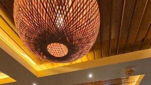 A modern dining area with a wooden ceiling, recessed lighting, and a view into the adjacent room. - White Dove Luxurious Boutique Hotel (Mikir Para Chakardoi)