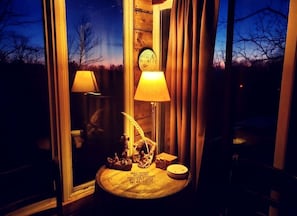 A room with a round table, two lamps, and a small decorative item with text.