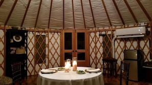 A round table with candles, plates, and cutlery in a tent with wooden lattice walls and a central door. - Luxurious Lakefront Yurt Rental for a Romantic Getaway near Grapevine, Texas (Southlake)