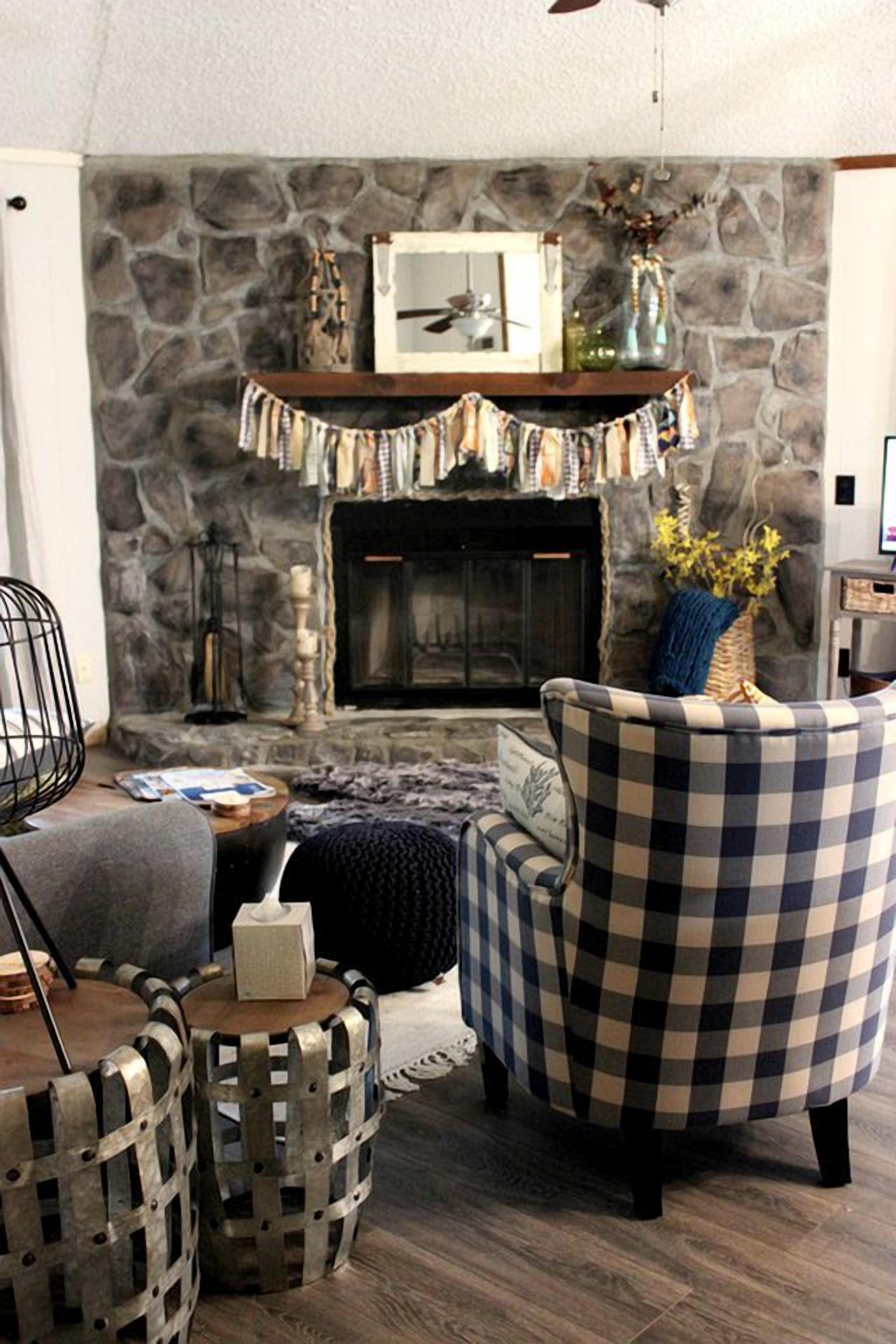 Un salon chaleureux avec une cheminée en pierre, un fauteuil à carreaux et un décor rustique.