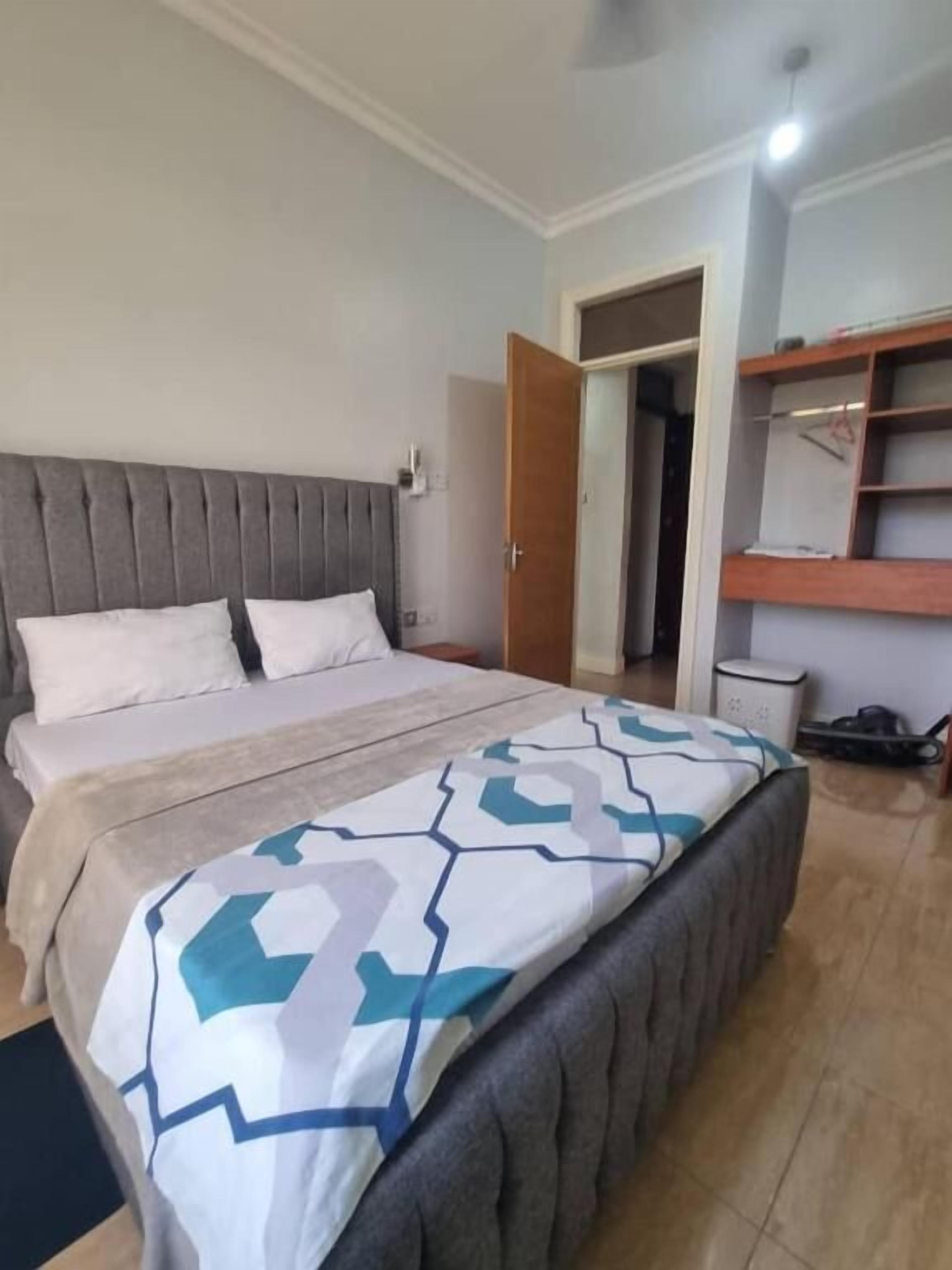 A bedroom with a bed, a wardrobe, and a mirror.