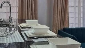 Una cocina con una isla central, un fregadero y dos lámparas colgantes.