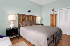 A bedroom with a bed, two bedside tables with lamps, a wooden headboard, a dresser, and a closet. - Amazing Sunrise at Coastal Luxury Cabin Rental on Herron Island with Fire Pit and Paddle Boarding near Olympia, Washington (Lakebay)
