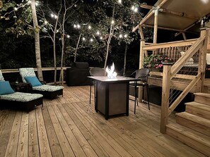An outdoor deck with a fire feature, seating, and a staircase.
