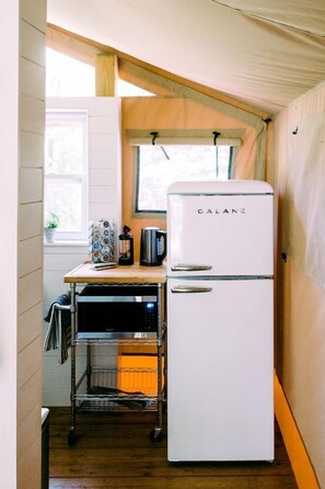 A compact kitchen with a white Galanz refrigerator, a coffee maker, and a microwave on a metal cart.