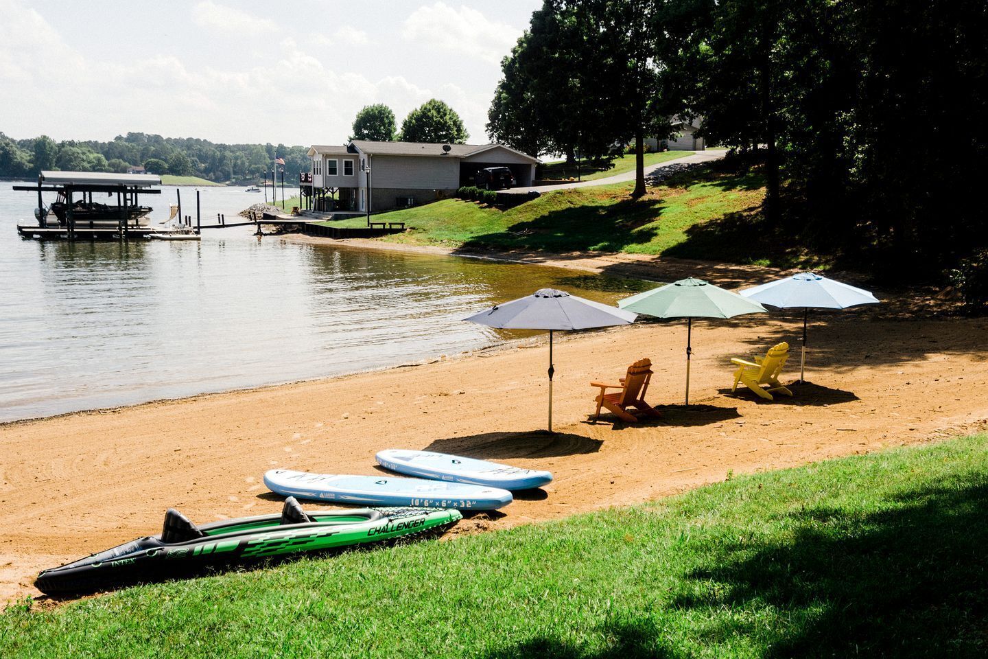 Une plage avec des kayaks, des chaises de plage et des parasols.