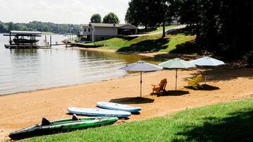 Une plage avec des kayaks, des chaises de plage et des parasols.