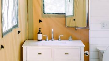 Une petite salle de bain avec un meuble-lavabo blanc, un miroir et des toilettes.