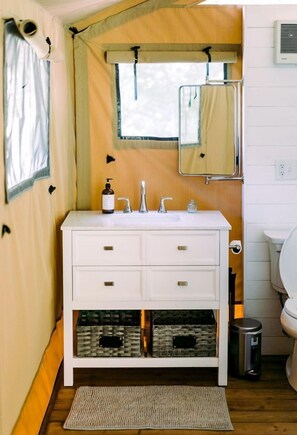 Une petite salle de bain avec un meuble-lavabo blanc, un miroir et des toilettes.