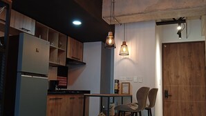 Eine moderne Küche mit Holzausstattung, einem integrierten Kühlschrank und einem Essbereich mit Tisch und Stühlen.