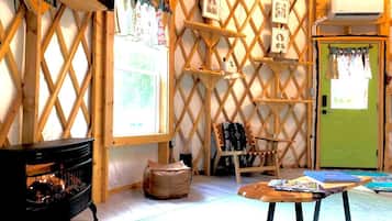 A cozy room with a fireplace, a green door, and a lattice wall with framed pictures.