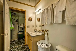 Ein Badezimmer mit Waschbecken, Spiegel, Handtuchhalter und Mülleimer.