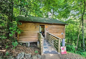 Eine Holzhütte mit Veranda, Treppe und einer Willkommensschild.