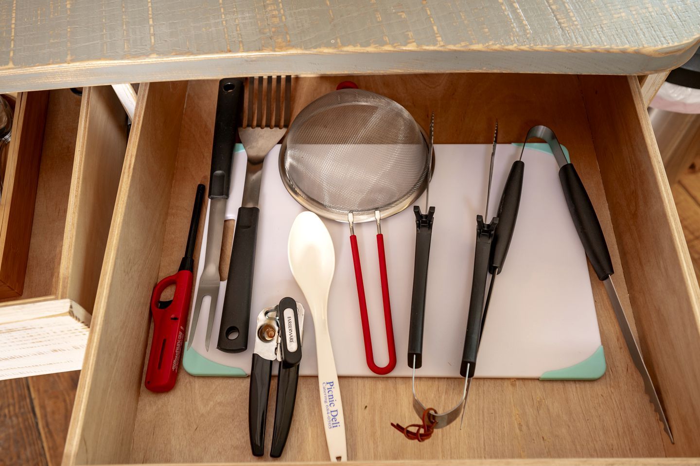 A drawer with various kitchen utensils and tools.