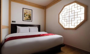 A bedroom with a bed, a painting on the wall, and a window with a geometric pattern. - Yuseong Manwol Hotel (Hanok) (Daejeon)