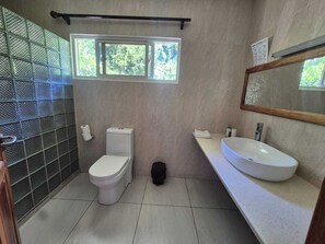 Un baño con inodoro, lavamanos y ventana.