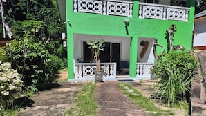 A two-story building with a green facade and white balcony railings. - Fond B'offay Lodge (Praslin Island)