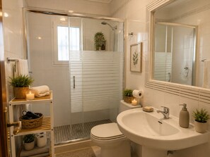 A modern bathroom with a shower, toilet, sink, and a large mirror. - Ground Floor in Playa Flamenca with Pool (Alicante)