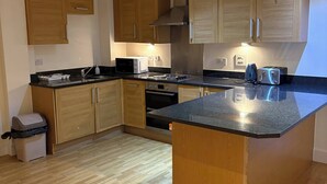 Een moderne keuken met houten kastjes, een centraal eiland en inbouwapparatuur.