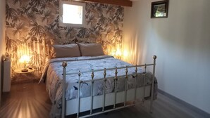 Um quarto com uma cama, uma janela, uma luminária e um quadro na parede.