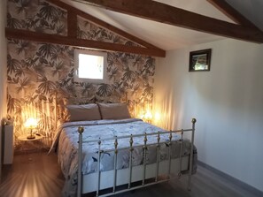 A bedroom with a bed, a window, a lamp, and a framed picture on the wall. - Country house 10 minutes from the sea (by car) (Trégomeur)