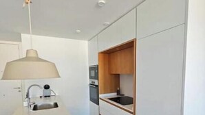 A modern kitchen with a white countertop, a sink, and a wooden cabinet. - New apartment near the beach - medium term stays (ideal for couples) (Torre del Mar)