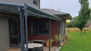 Une maison avec un patio couvert, une table à manger et des chaises.