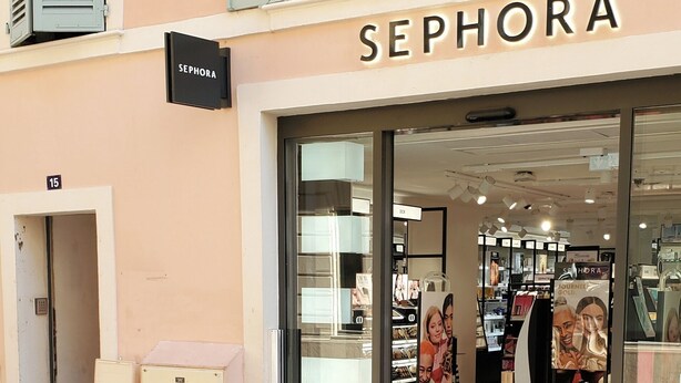 Ein Sephora Geschäft mit Glastür, einem Schild über der Tür und einer Schaufensterfront.