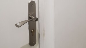Eine weiße Tür mit einem Metallgriff und der Zahl 3 an der Wand.