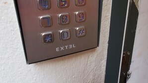 Ein Tastenfeld-Schloss an der Wand, beschriftet mit 'EXTEL'.