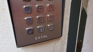 Ein an der Wand montiertes Tastaturfeld mit nummerierten Tasten und dem Markennamen 'EXTEL'.